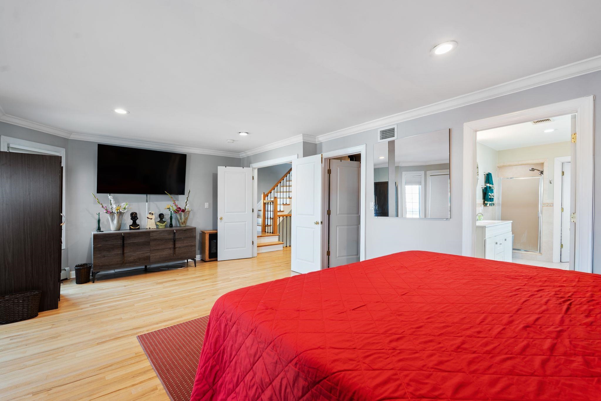 88 Myrtle Avenue, Unit B Edgewater, NJ 07020 - Photo 19 of 49 a spacious bedroom with a bed and a flat screen tv