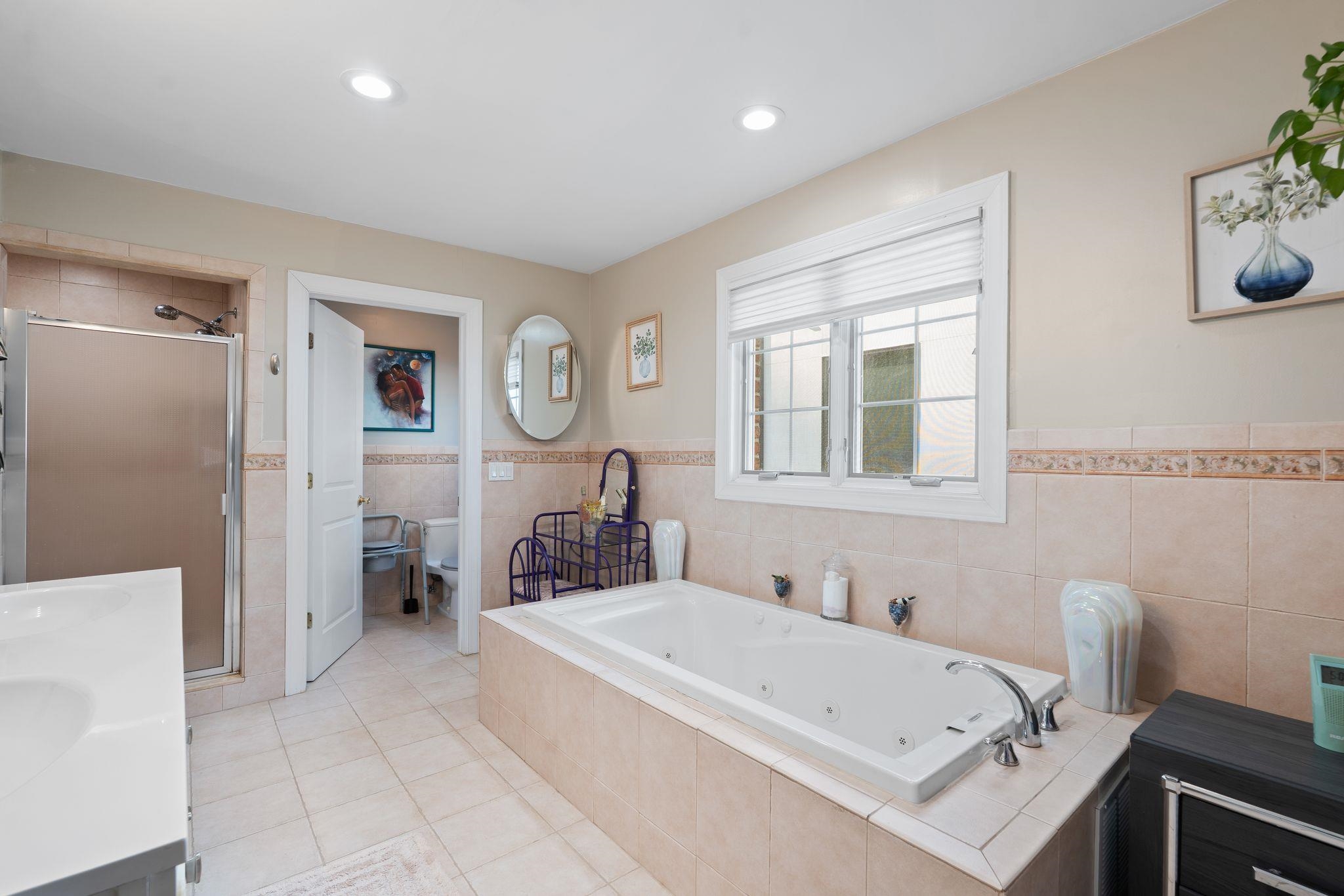 88 Myrtle Avenue, Unit B Edgewater, NJ 07020 - Photo 20 of 49 a bathroom with a tub a sink and a mirror