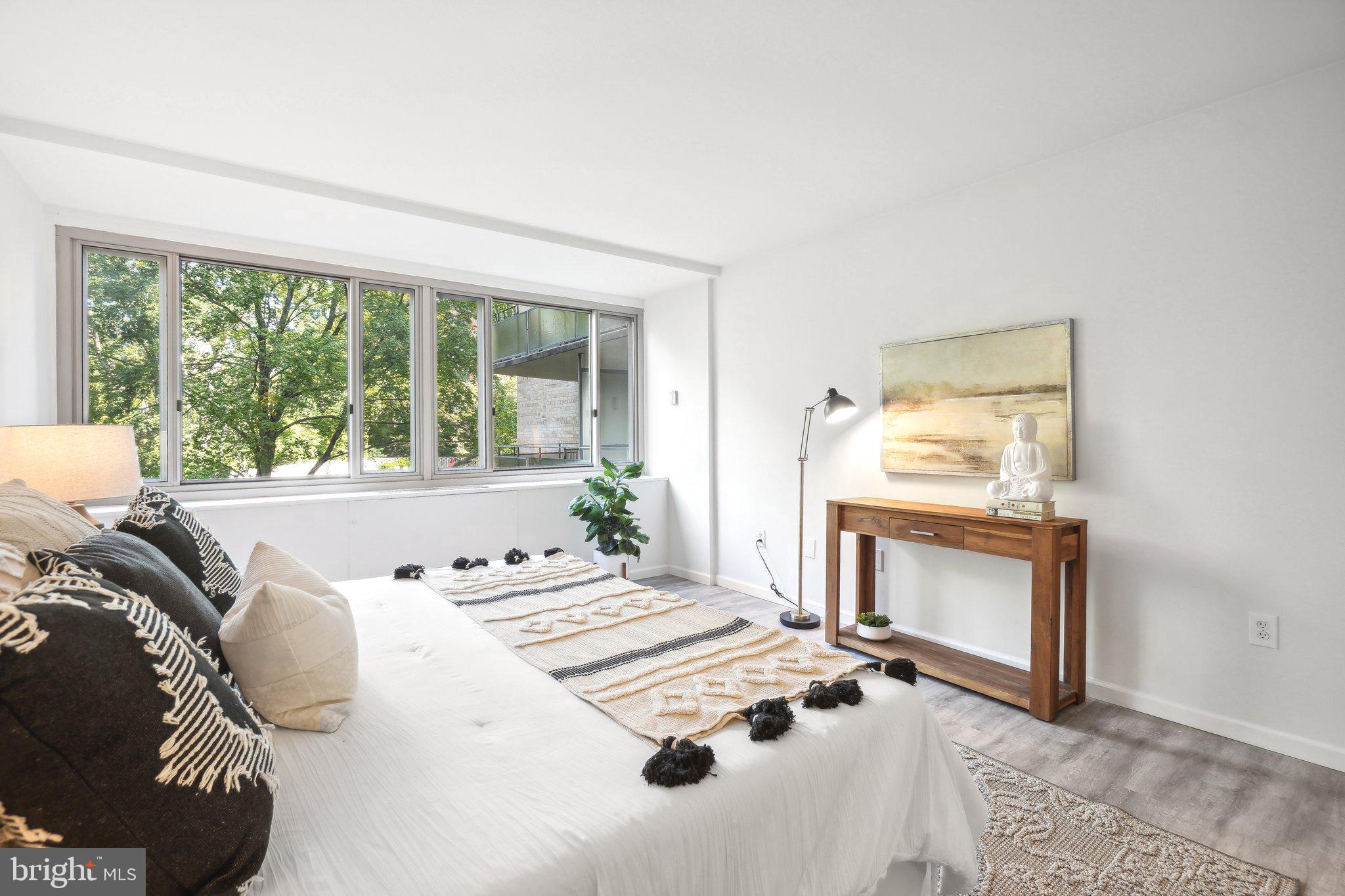 4101 Cathedral Avenue Northwest, Unit 306 Washington, DC 20016 - Photo 11 of 31 a living room with a bed and a fireplace