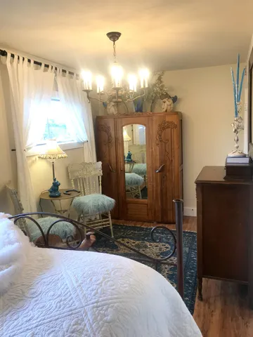 a spacious bedroom with a bed a chandelier and a window