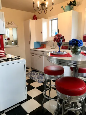 a kitchen with stainless steel appliances a dining table and chairs