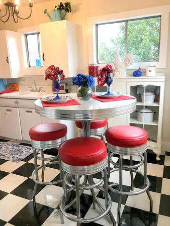 a kitchen with a stove a table and chairs