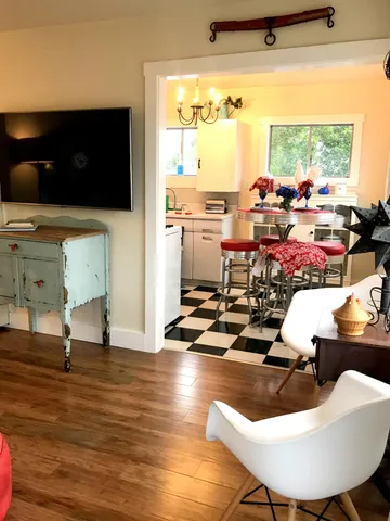 a room with wooden floor dining table and a large window