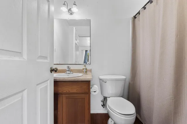 a bathroom with a toilet a sink and mirror