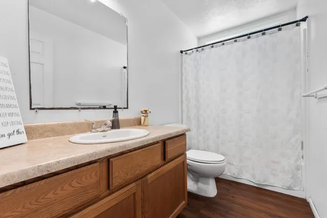 a bathroom with a granite countertop sink toilet and a mirror