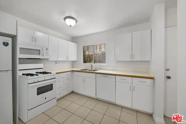 a kitchen with granite countertop white cabinets and white appliances