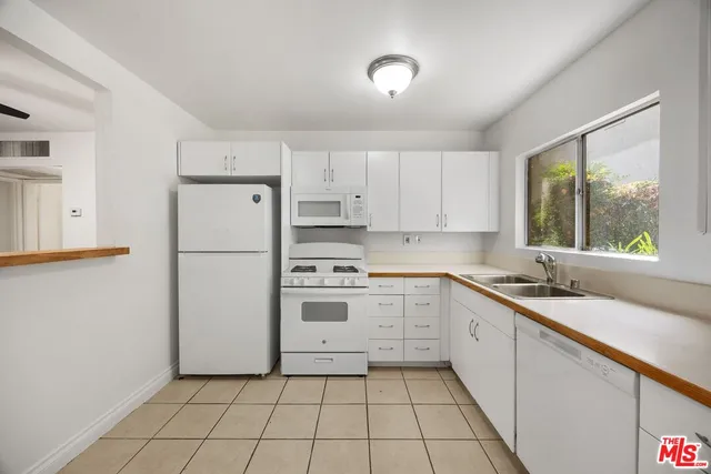 a kitchen with a sink a refrigerator and cabinets