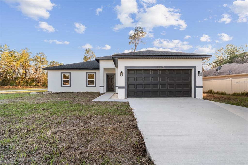 16224 Southwest 55th Court Road Ocala, FL 34473 - Photo 1 of 1 a front view of a house with a yard and garage