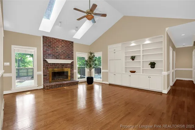 a view of a livingroom with wooden floor a fireplace and window