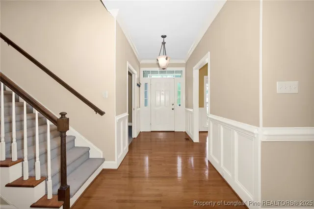 a view of a hallway with wooden floor and staircase