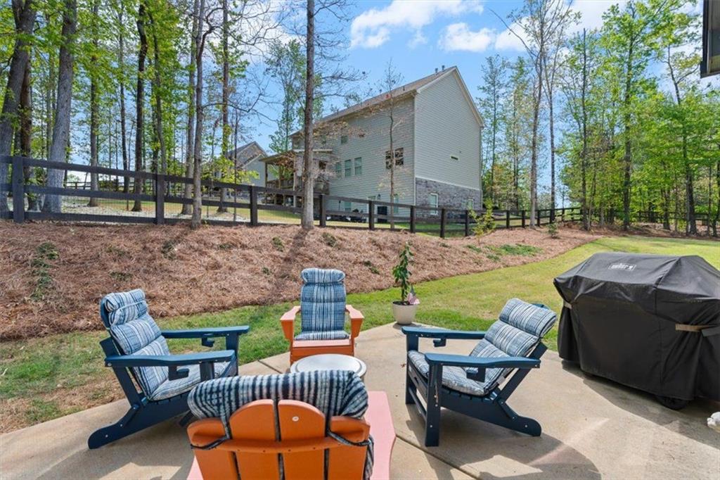 7610 Scenic Overlook Cumming, GA 30041 - Photo 40 of 62 a view of a patio with table and chairs under an umbrella with large trees