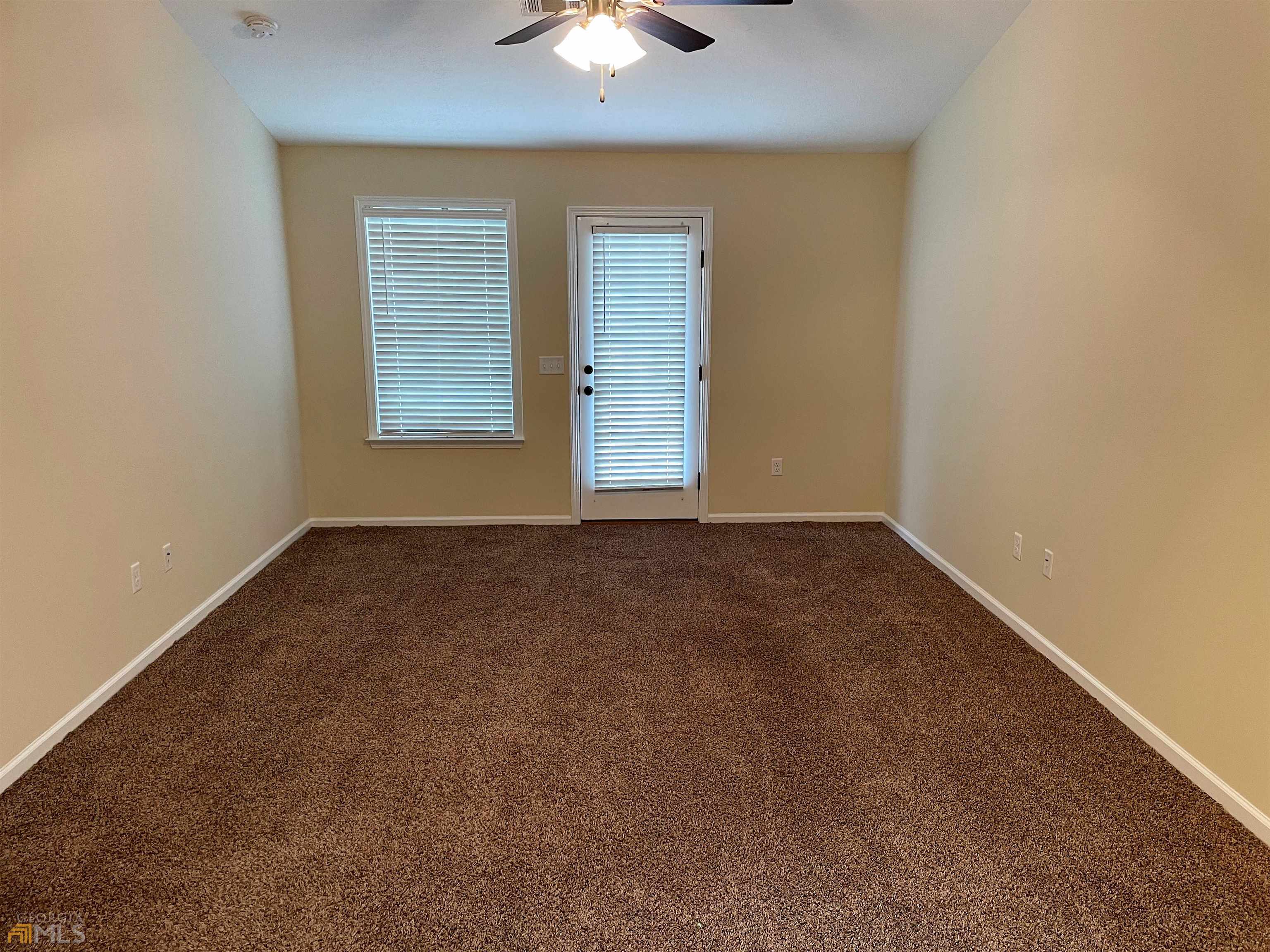 148 Buckhaven Way, Unit 148 Statesboro, GA 30458 - Photo 11 of 27 an empty room with a chandelier fan and windows