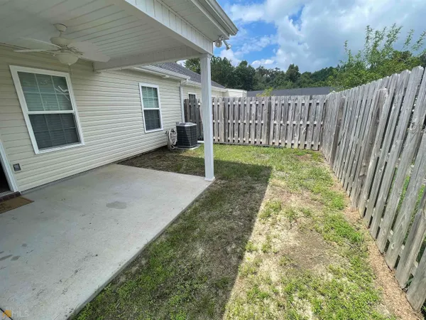 a view of backyard with wooden fence