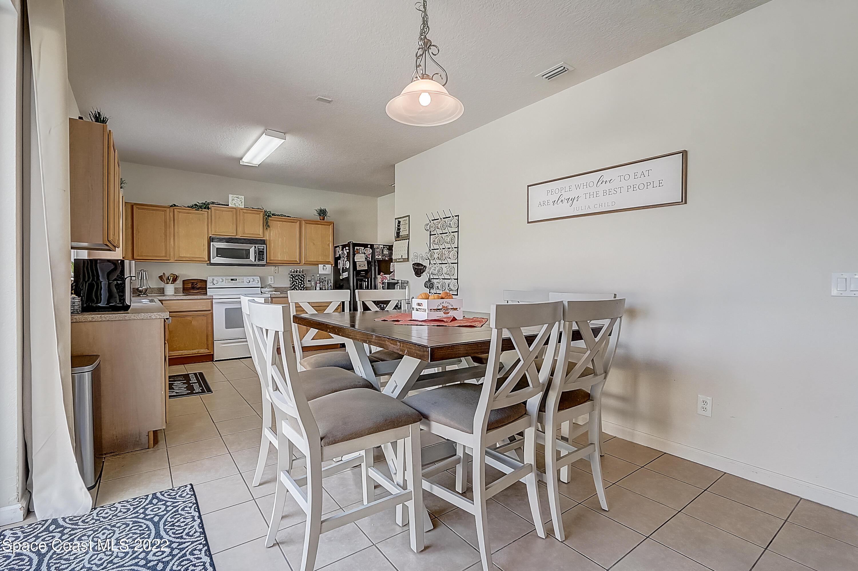 3687 Mt Carmel Lane Melbourne, FL 32901 - Photo 12 of 46 a dining room with furniture and kitchen view