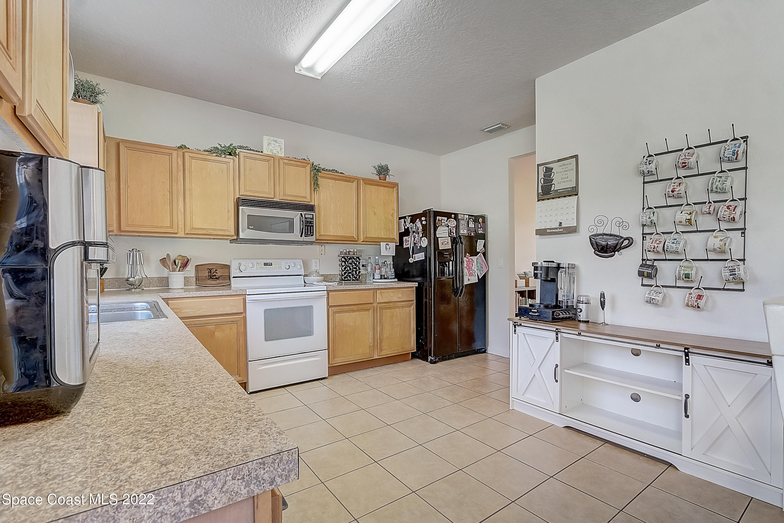 3687 Mt Carmel Lane Melbourne, FL 32901 - Photo 14 of 46 a kitchen with white cabinets and appliances