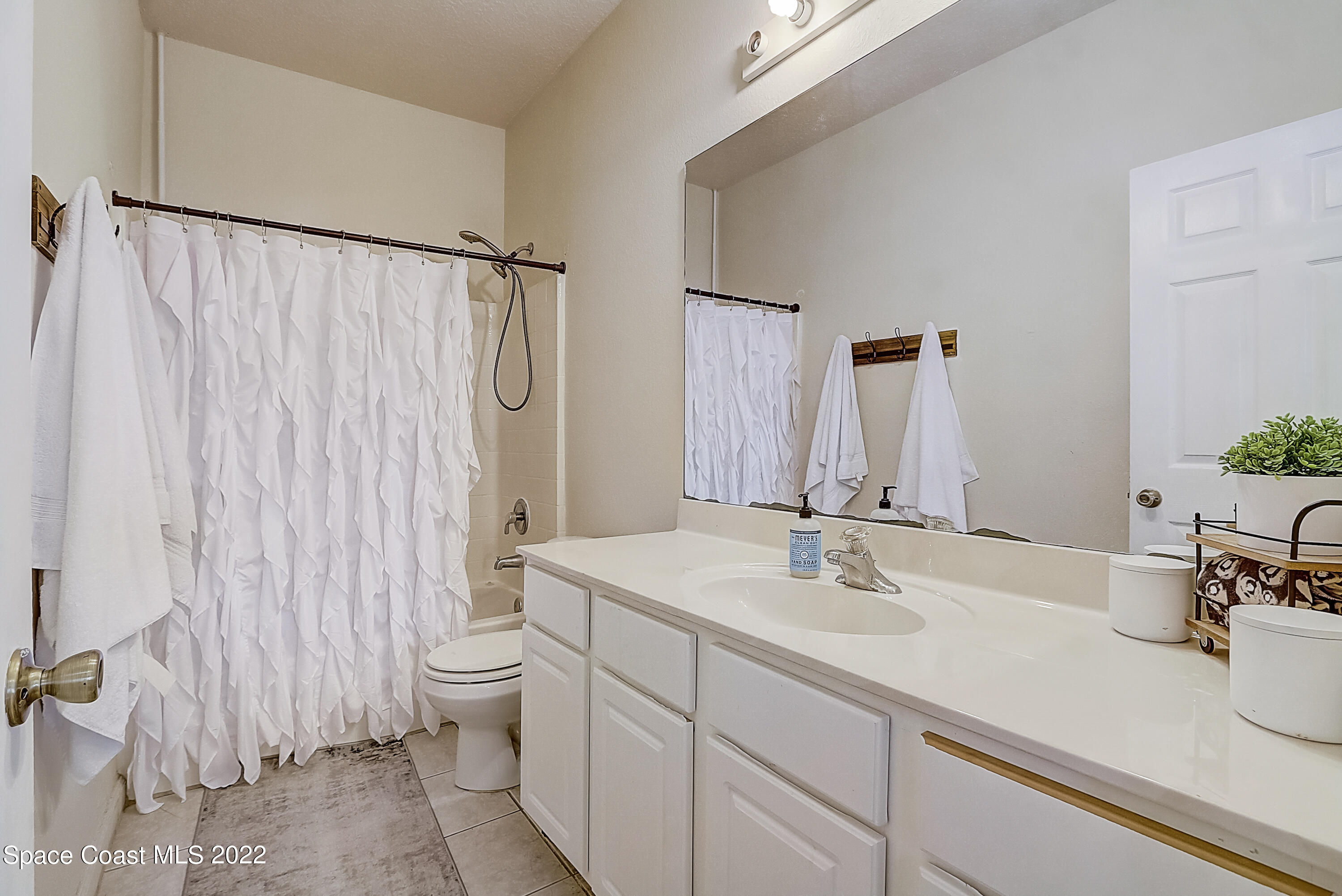 3687 Mt Carmel Lane Melbourne, FL 32901 - Photo 23 of 46 a bathroom with a sink and a mirror