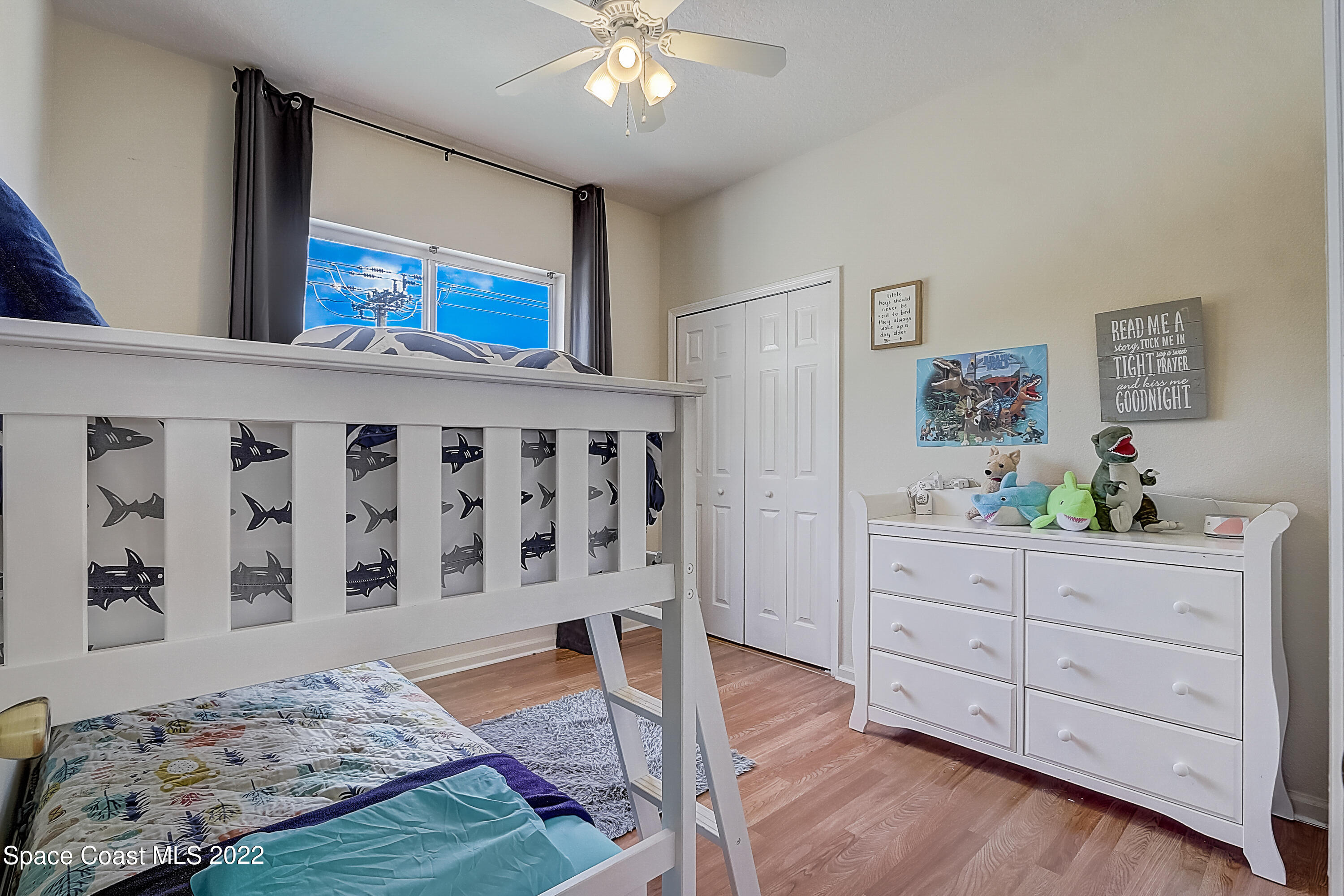 3687 Mt Carmel Lane Melbourne, FL 32901 - Photo 24 of 46 a view of a bedroom with wooden floor and cabinet