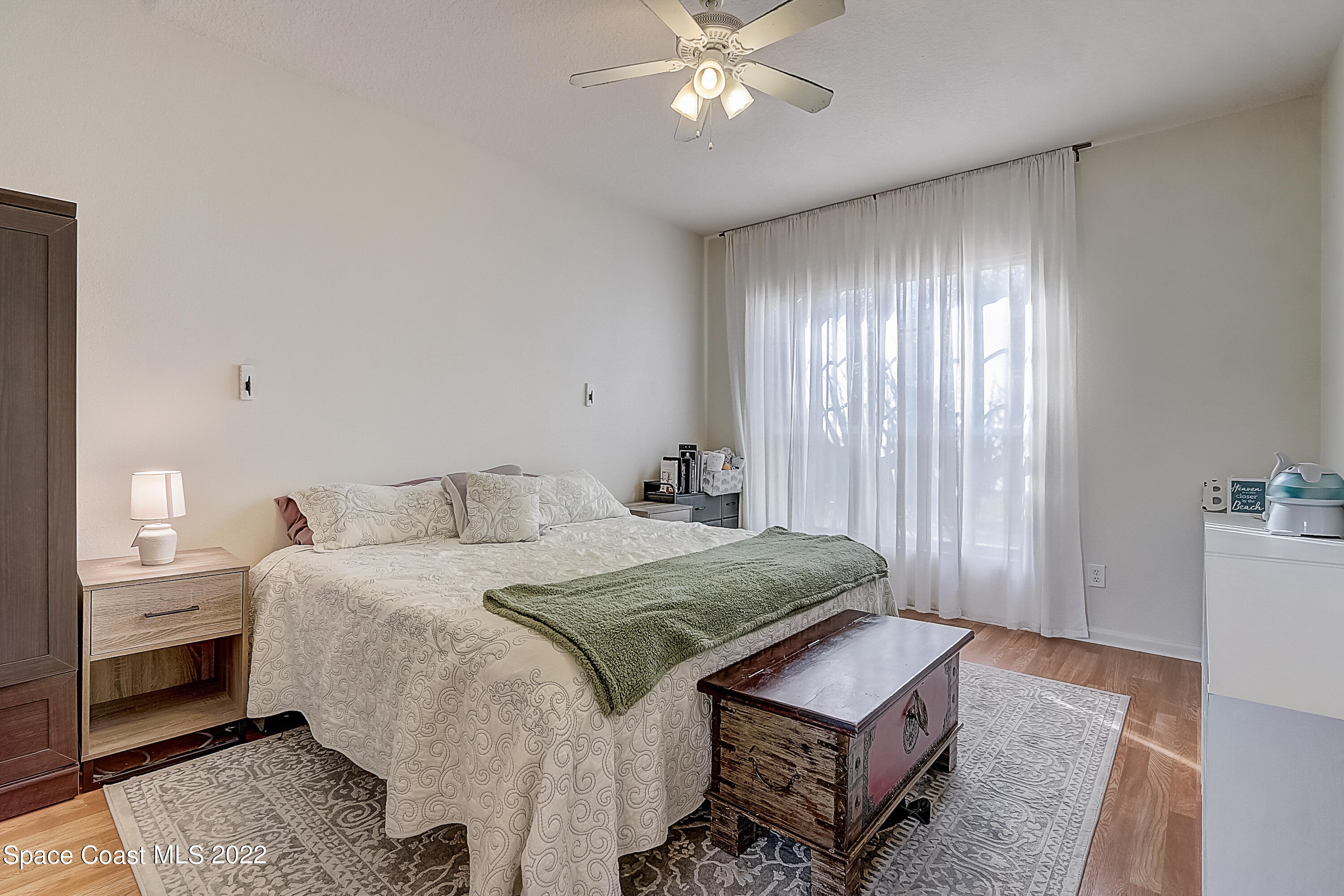 3687 Mt Carmel Lane Melbourne, FL 32901 - Photo 26 of 46 a bedroom with a bed and a lamp with window