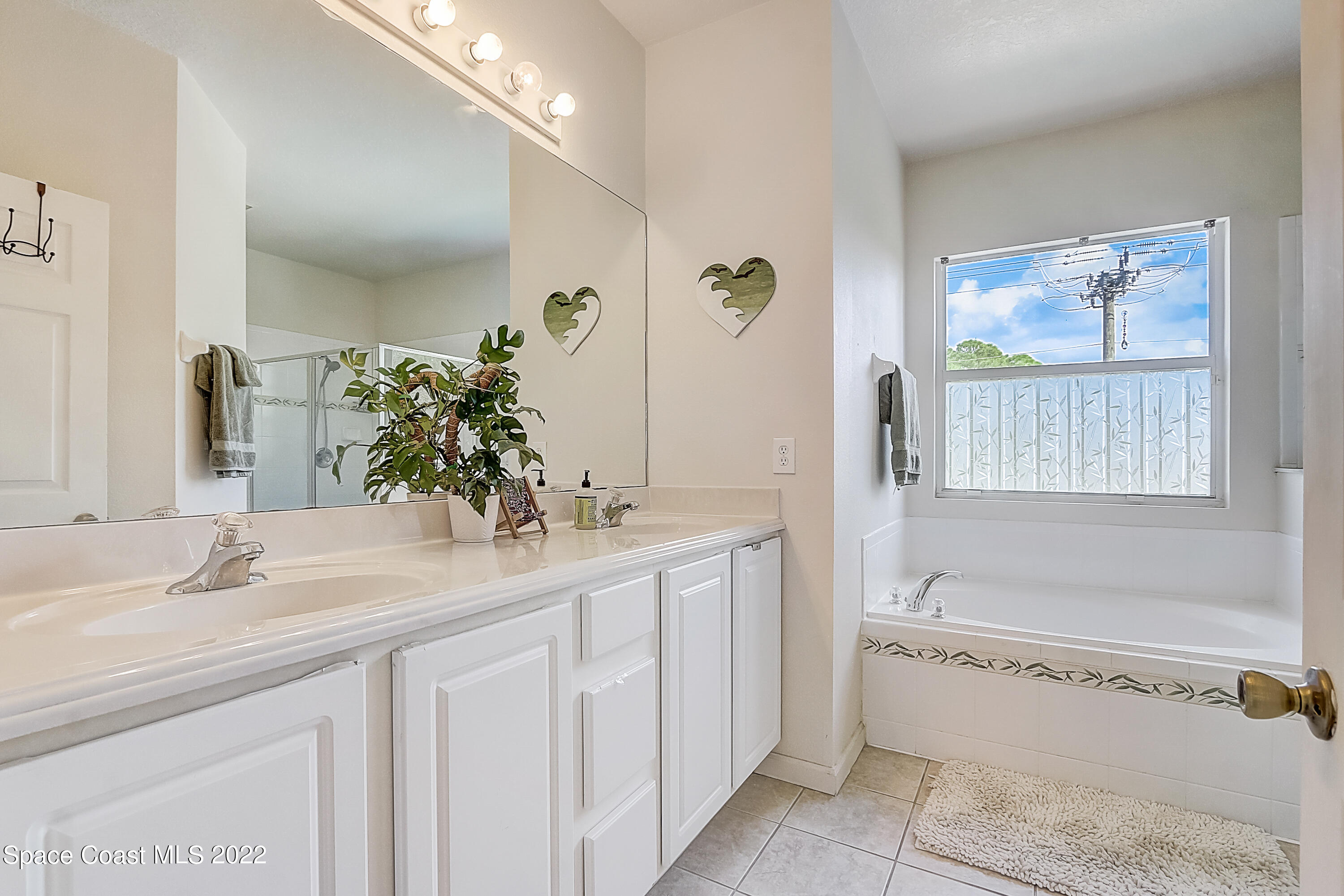 3687 Mt Carmel Lane Melbourne, FL 32901 - Photo 29 of 46 a bathroom with a tub a sink and mirror