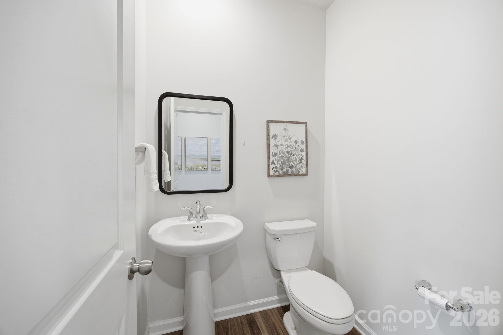 234 Hamptons Cove Road Troutman, NC 28166 - Photo 5 of 32 a bathroom with a toilet a sink and mirror