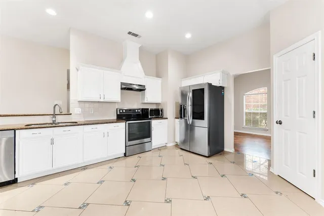 a kitchen with granite countertop white cabinets and appliances