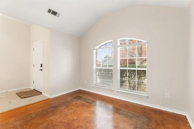 a view of an empty room with a fireplace and a window