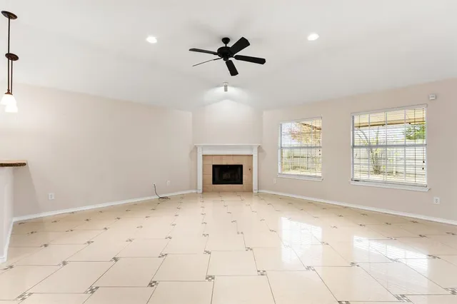 a view of an empty room with a fireplace and a window