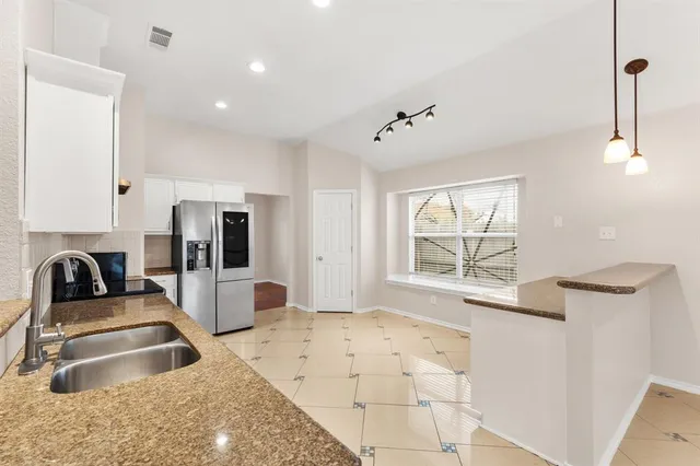 a kitchen with white cabinets appliances and a sink