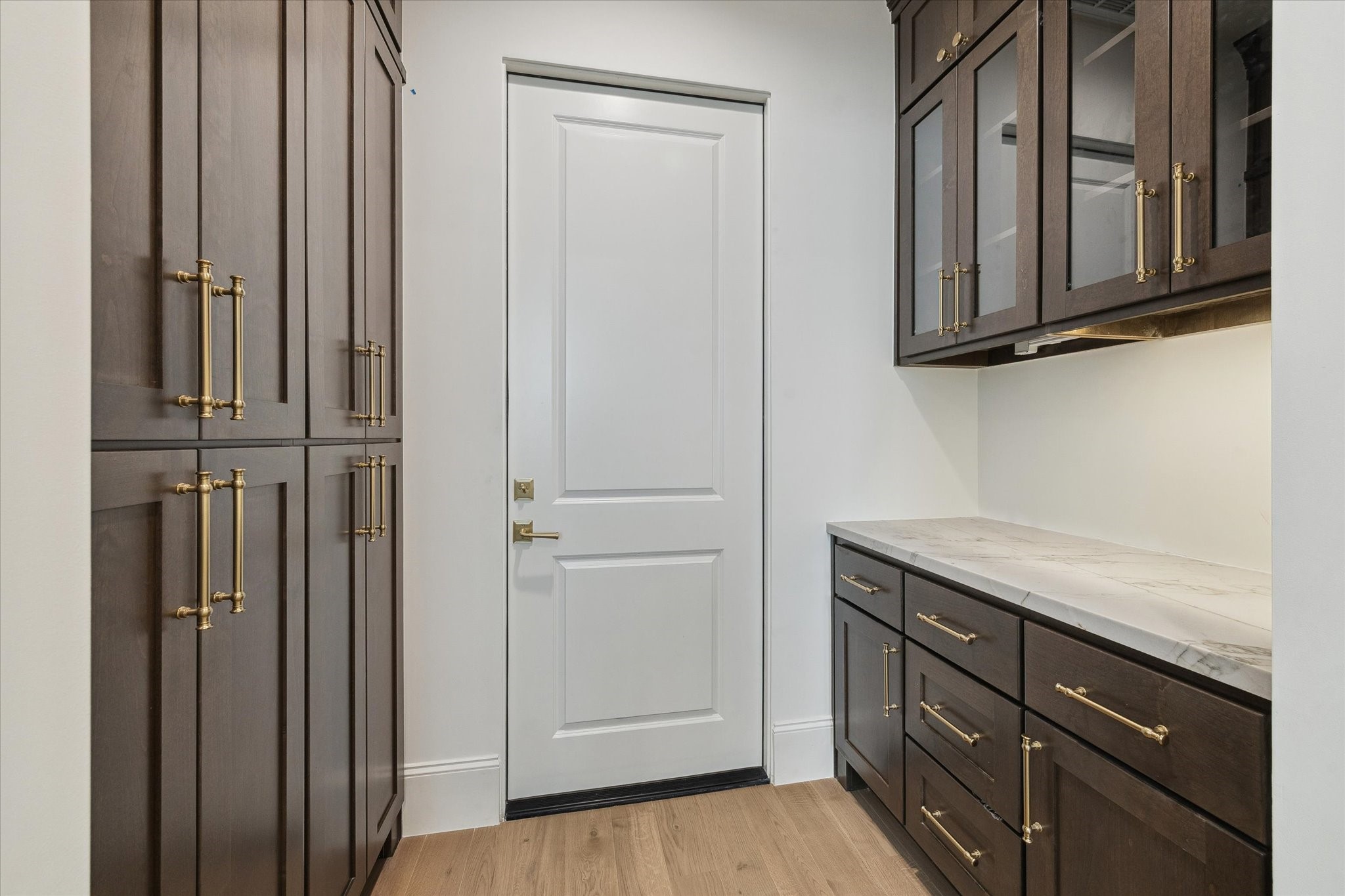 25 Wentworth Gate Path Houston, TX 77027 - Photo 12 of 32 Off the kitchen is the pantry with excessive vertical cabinetry, as well as secondary space with countertop and glass-face cabinetry above to use as storage, additional prep space, or a dry bar area!