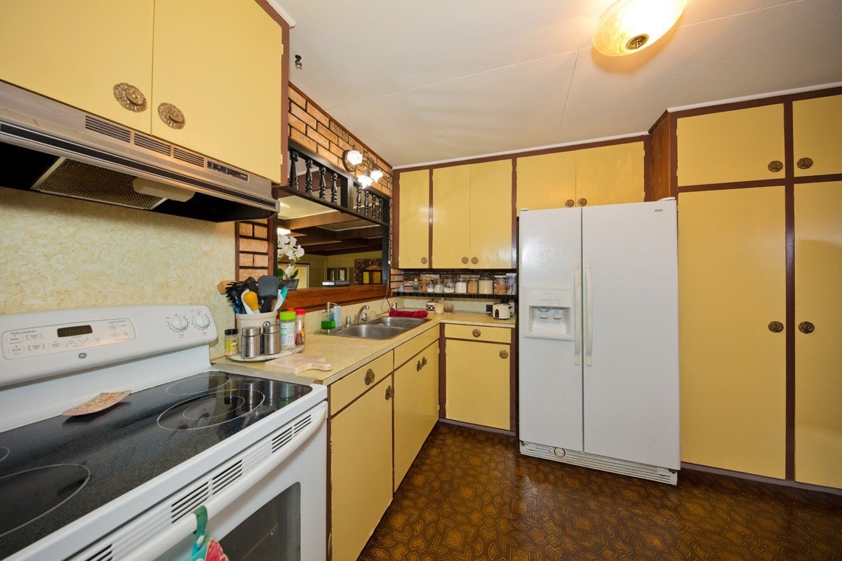 25 Kaapuni Loop Hilo, HI 96720 - Photo 11 of 25 a kitchen with a refrigerator and a stove