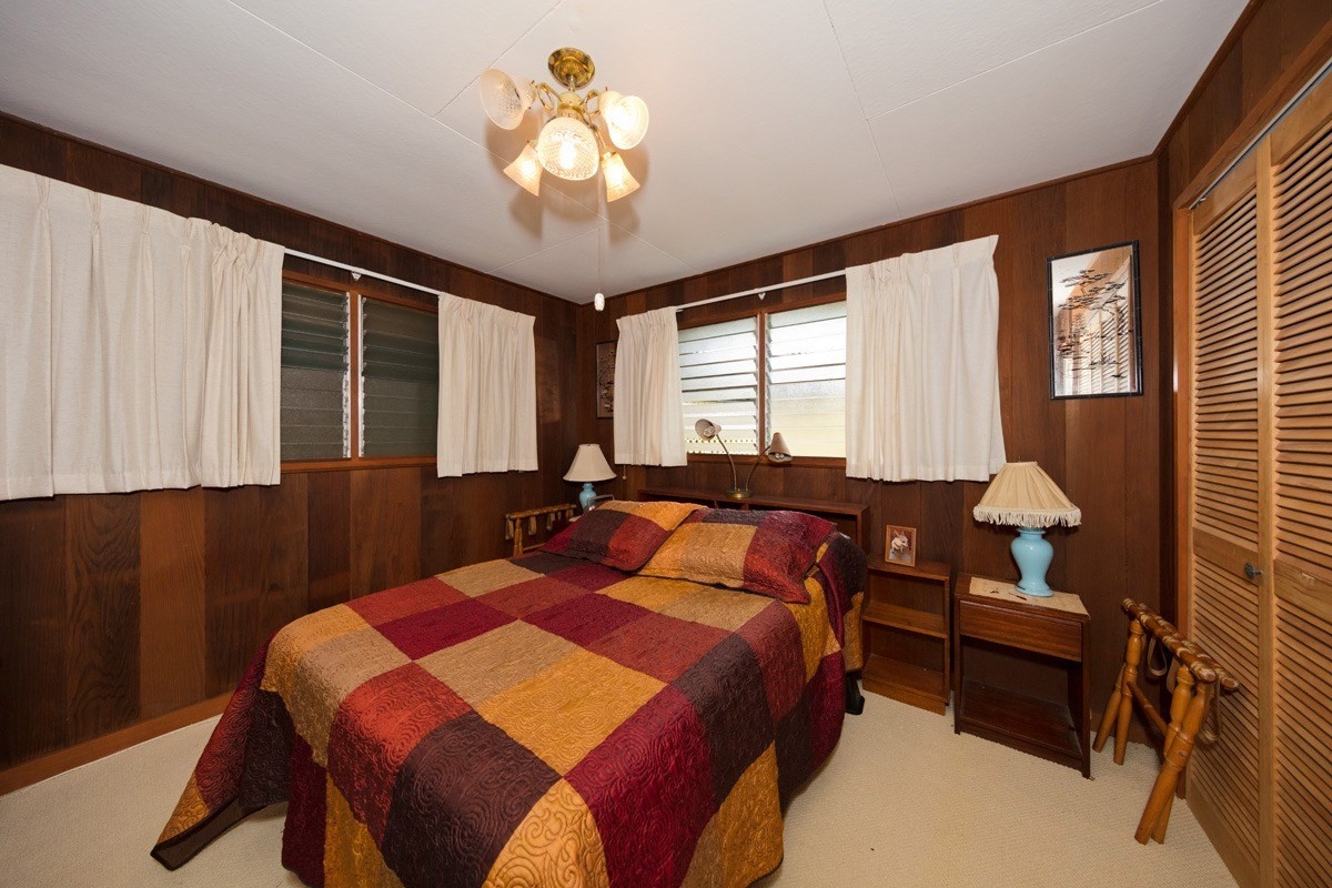 25 Kaapuni Loop Hilo, HI 96720 - Photo 18 of 25 a bedroom with a bed and a chandelier