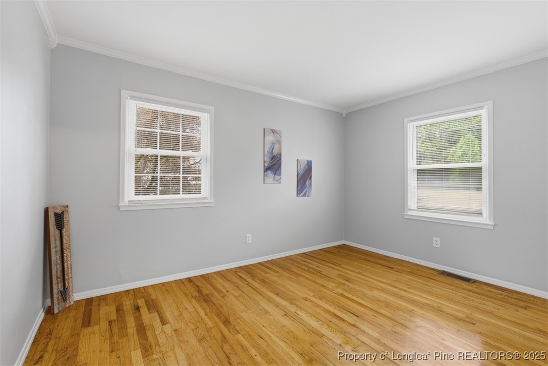1109 Strickland Bridge Road Fayetteville, NC 28304 - Photo 13 of 20 a view of a bedroom with wooden floor and a window