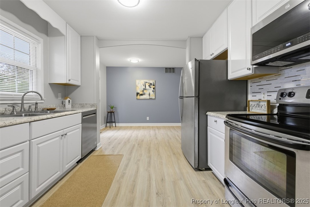 1109 Strickland Bridge Road Fayetteville, NC 28304 - Photo 7 of 20 a kitchen with granite countertop a refrigerator stove and sink