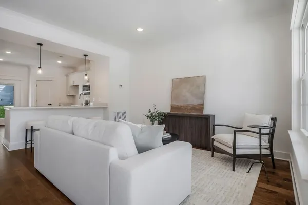 a living room with furniture and a dining table with wooden floor