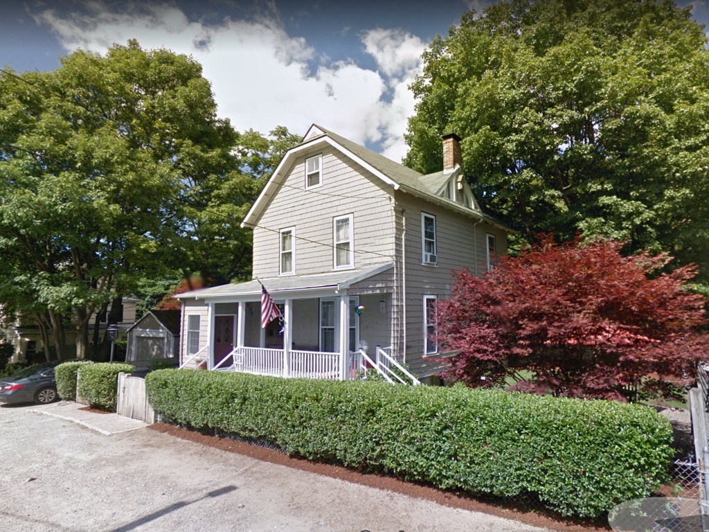 a view of a house with a yard and potted plants