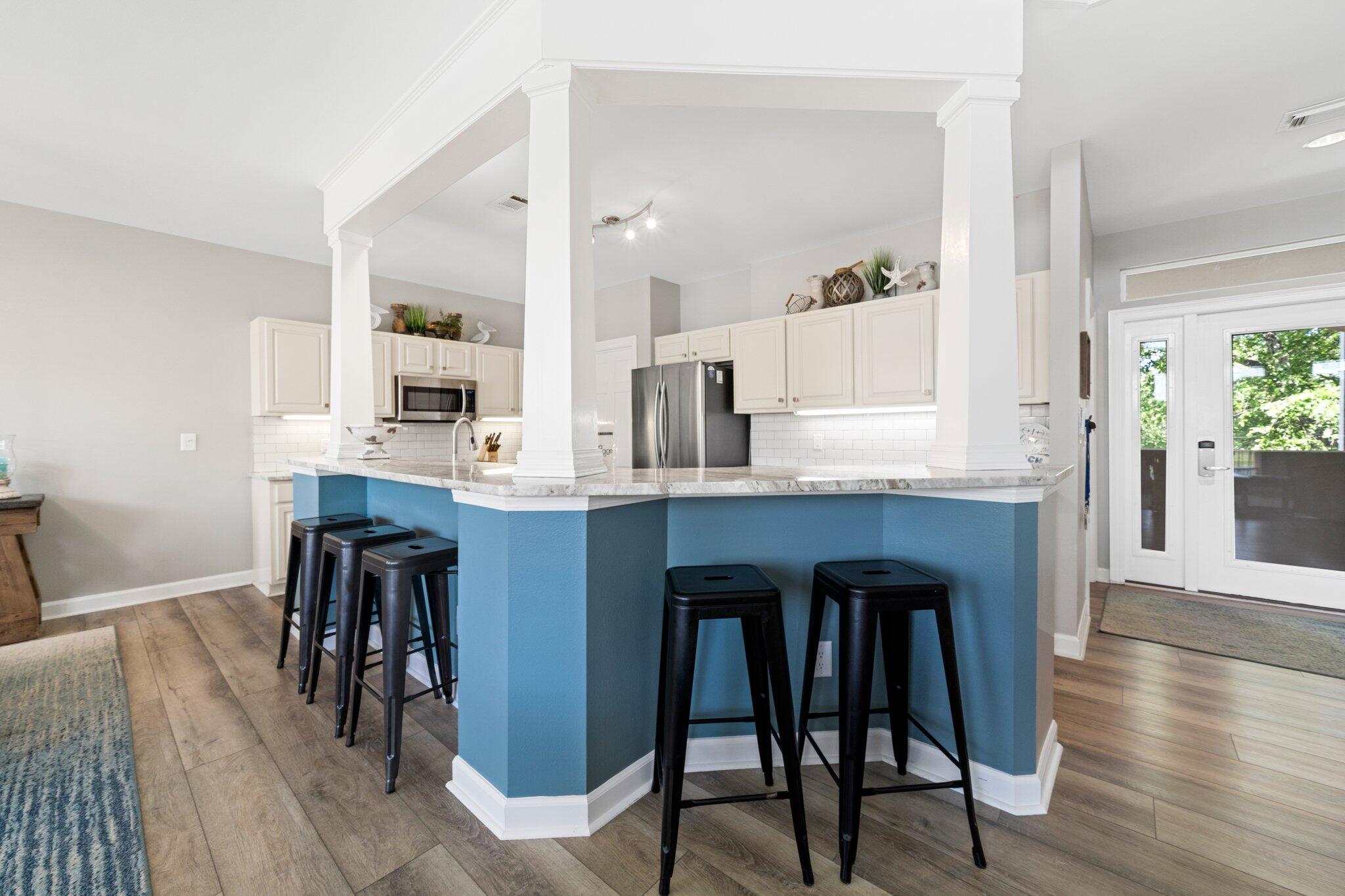 8512 Turnberry Court, Unit 8512 Miramar Beach, FL 32550 - Photo 15 of 35 a open kitchen with granite countertop a dining table chairs and white cabinets