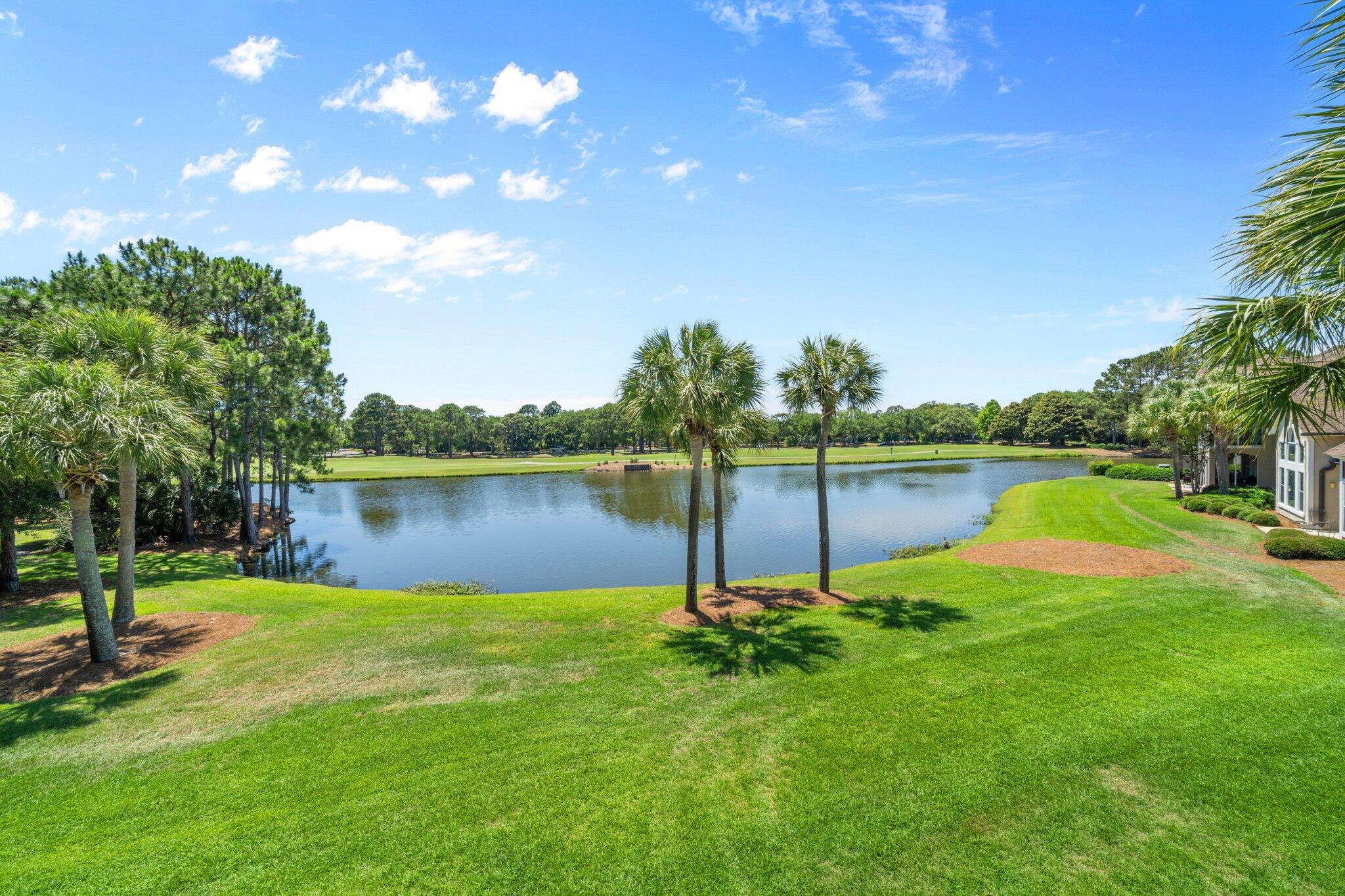 8512 Turnberry Court, Unit 8512 Miramar Beach, FL 32550 - Photo 21 of 35 a view of a lake with a big yard and palm trees