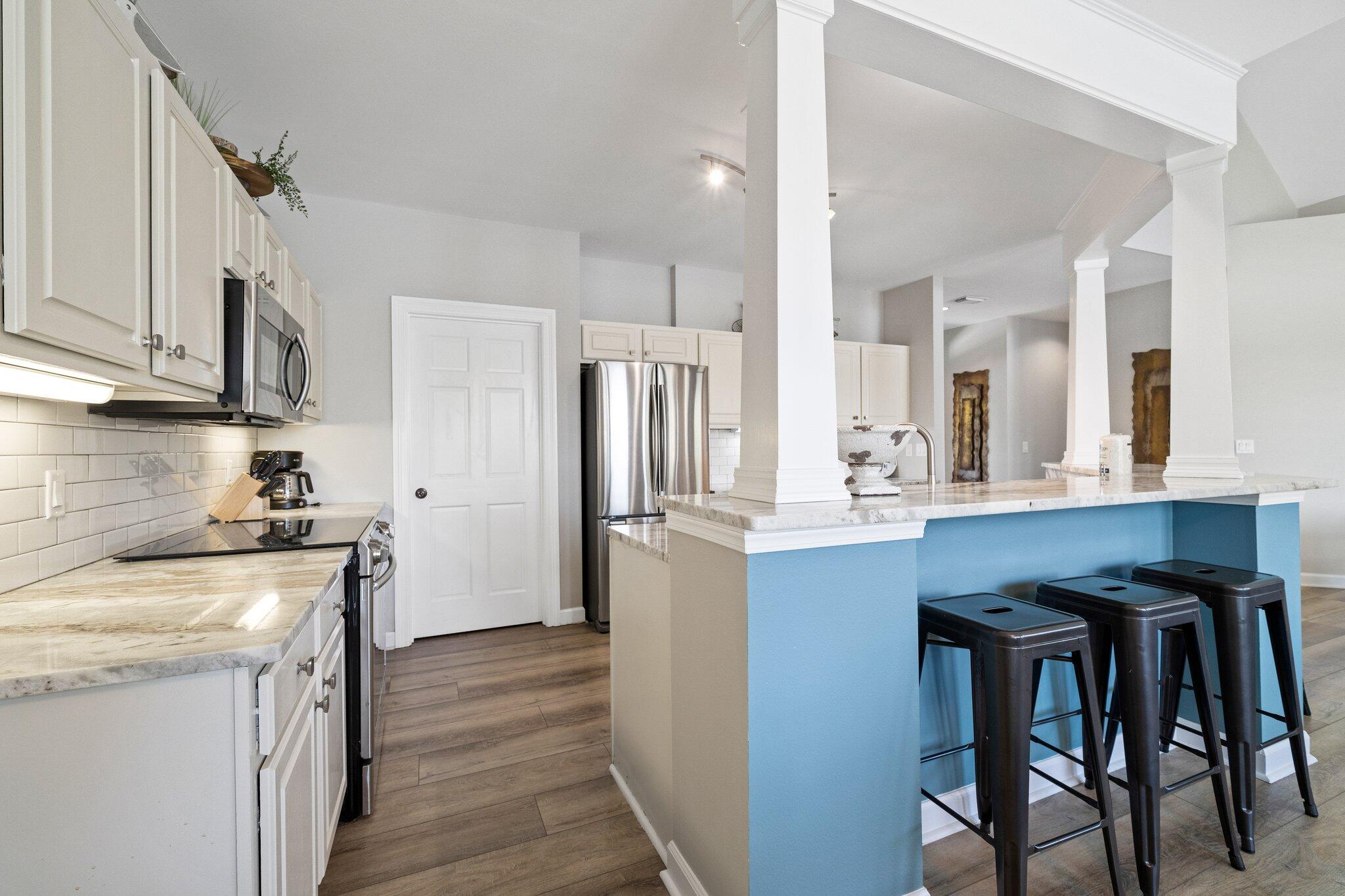 8512 Turnberry Court, Unit 8512 Miramar Beach, FL 32550 - Photo 10 of 35 a kitchen with stainless steel appliances granite countertop a table chairs stove a sink dishwasher and cabinets with wooden floor
