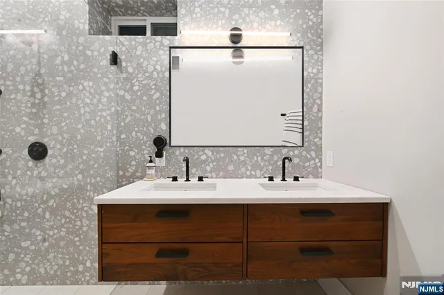 a bathroom with a double vanity sink toilet and shower
