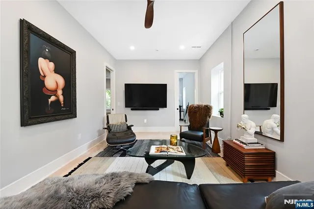 a living room with furniture a flat screen tv and a floor to ceiling window