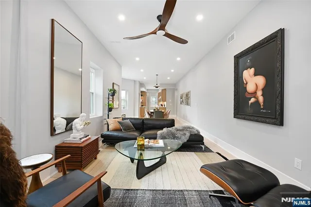 a living room with furniture and a ceiling fan