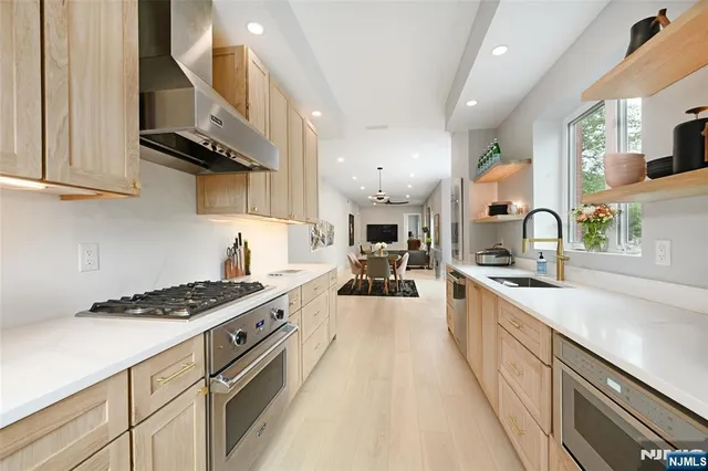 a kitchen with stainless steel appliances a sink stove and cabinets