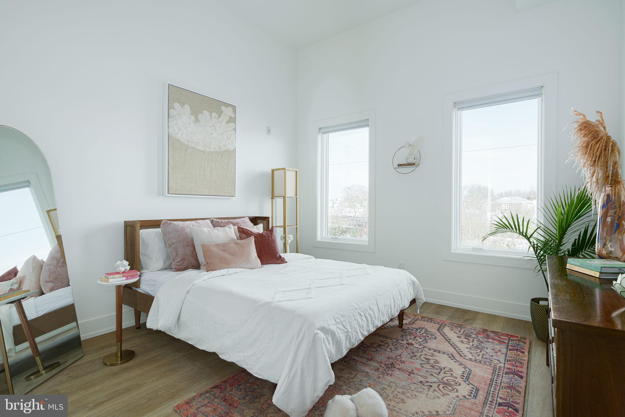 5013 Springfield Avenue, Unit 510 Philadelphia, PA 19143 - Photo 5 of 16 a bedroom with a large bed and a potted plant