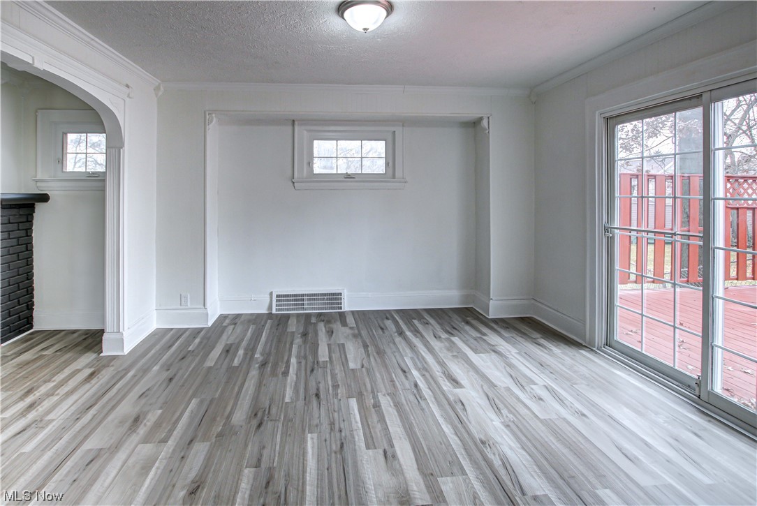 4764 Rockwood Road Cleveland, OH 44125 - Photo 14 of 35 Spare room featuring a textured ceiling, crown molding, and light hardwood / wood-style floors