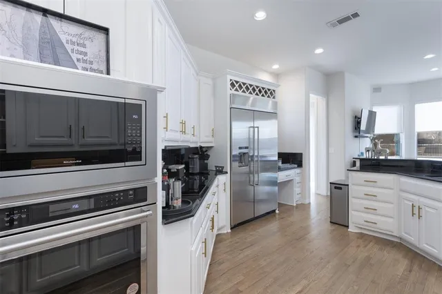 a kitchen with stainless steel appliances a stove microwave and refrigerator