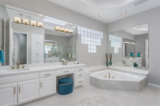 a bathroom with a granite countertop bathtub sink and mirror