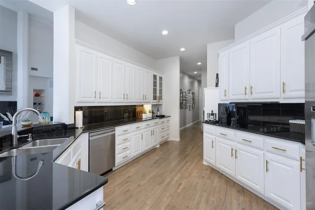 a kitchen with stainless steel appliances kitchen island granite countertop a sink a stove and cabinets