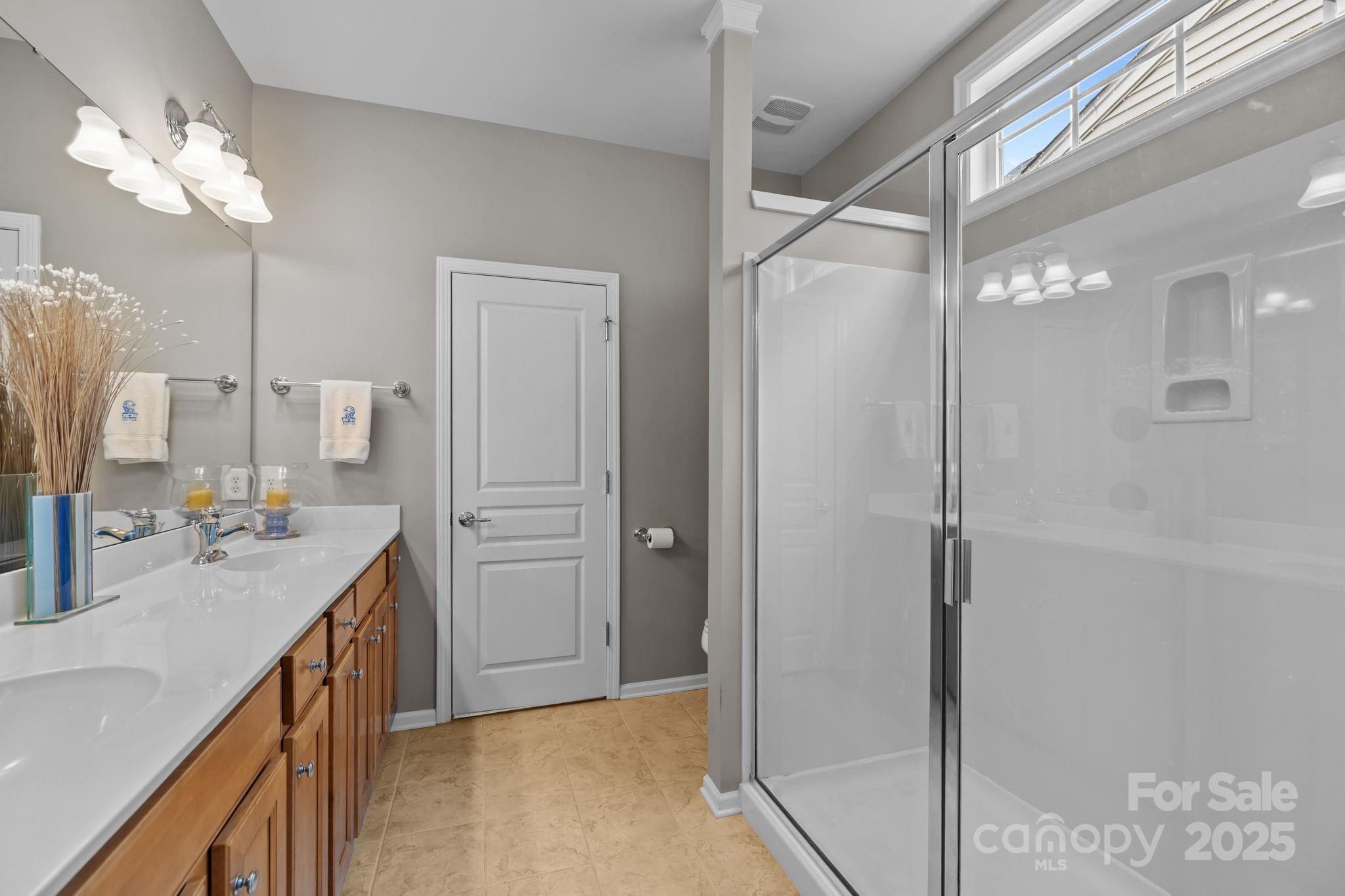 17517 Hawks View Drive, Unit 164 Fort Mill, SC 29707 - Photo 20 of 39 a bathroom with a granite countertop sink a shower and a mirror