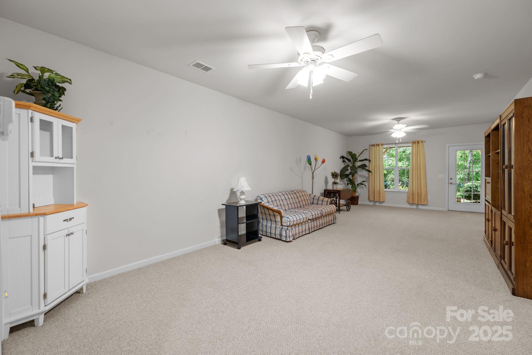 17517 Hawks View Drive, Unit 164 Fort Mill, SC 29707 - Photo 27 of 39 an empty room with chandelier fan and windows