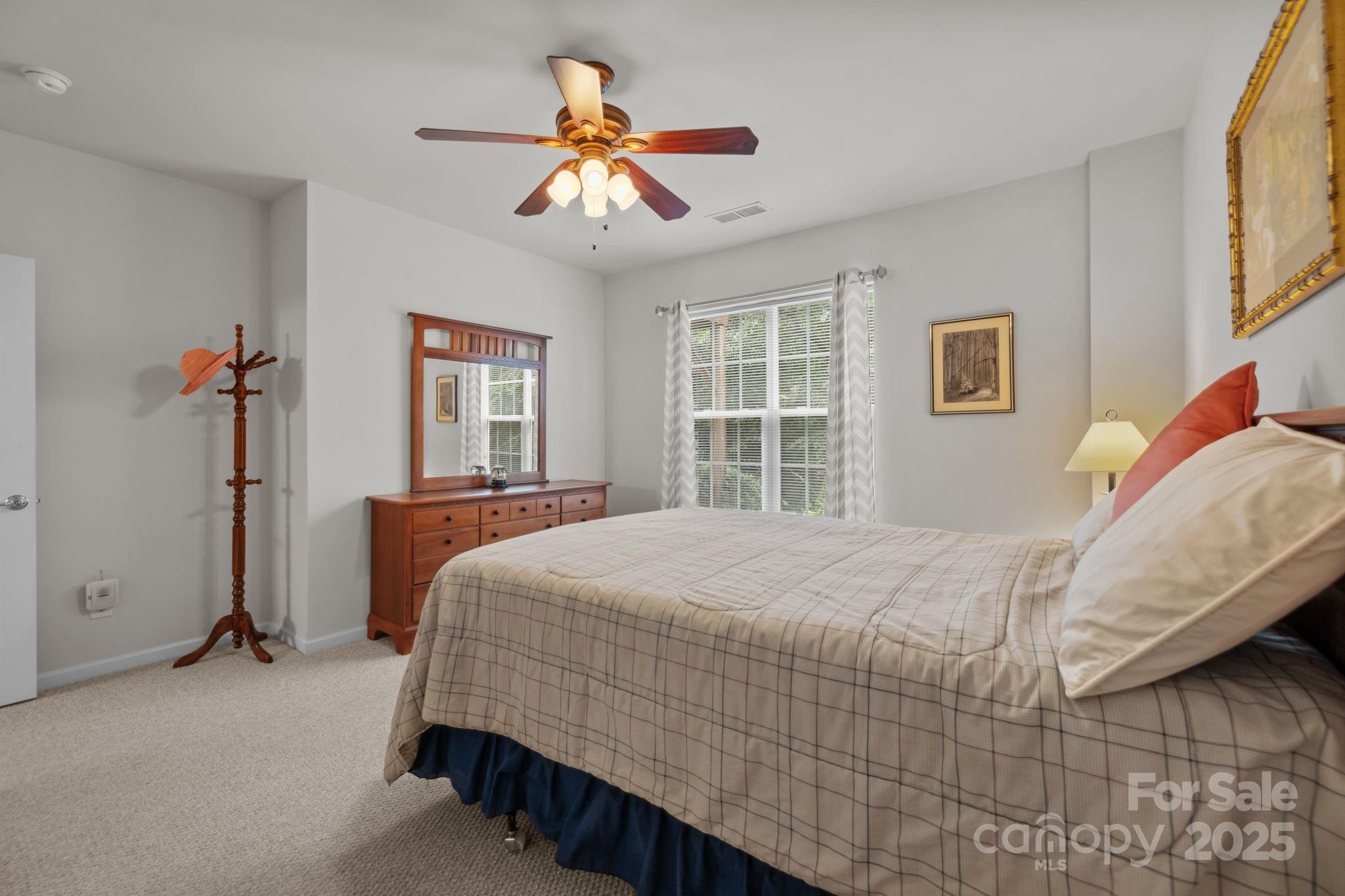 17517 Hawks View Drive, Unit 164 Fort Mill, SC 29707 - Photo 29 of 39 a bedroom with a large bed and a chandelier
